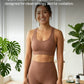 Woman in brown athletic wear standing in a bright room with plants and a table.